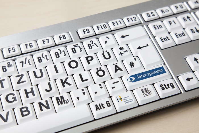 Eine Tastatur mit extra großen Buchstaben und dem Logo der Stiftung. Auf einer Taste steht "Jetzt Spenden!"